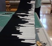 Mary Lou Dobson finished her black & white “City Skyline” shawl. Off loom and on long table to make the fringes. 